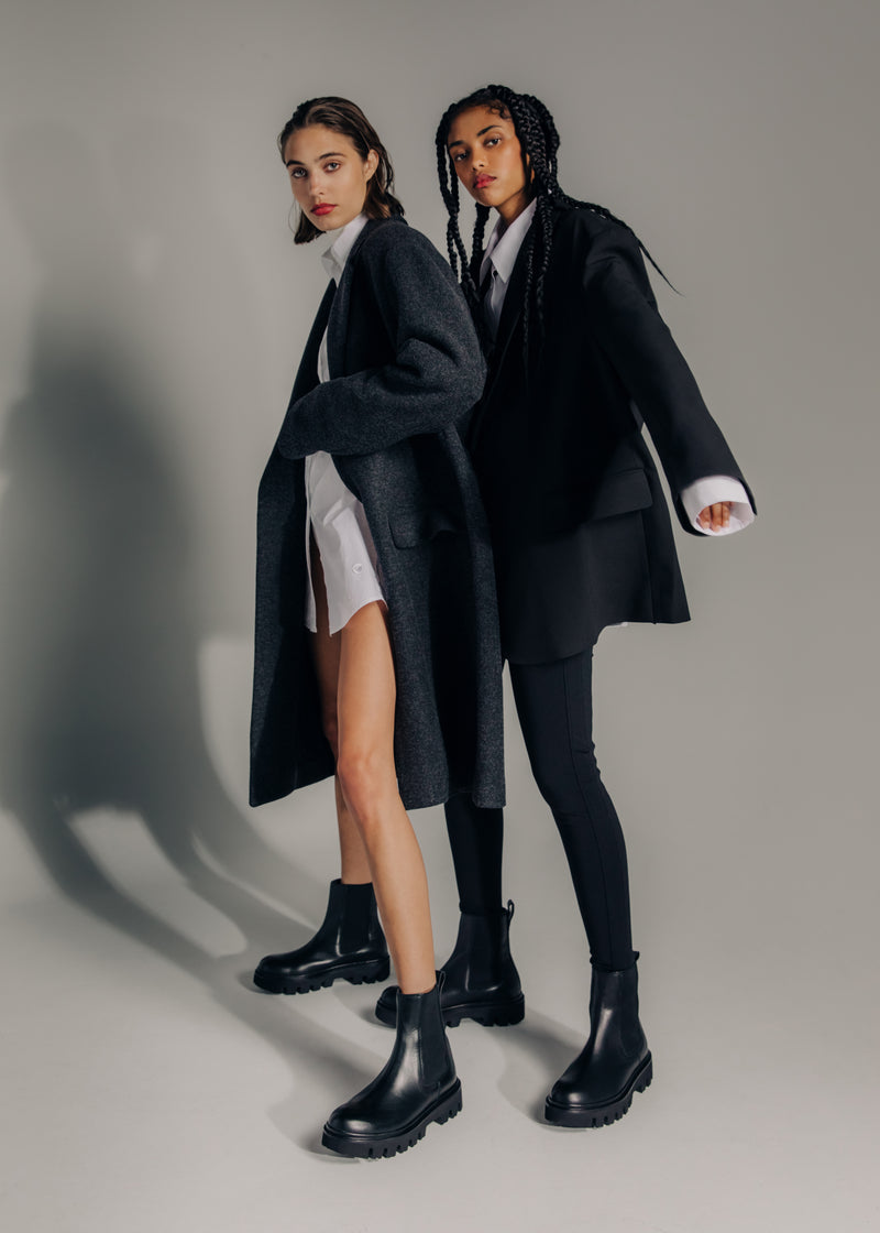 2 women standing wearing Italian black leather boots with track soles