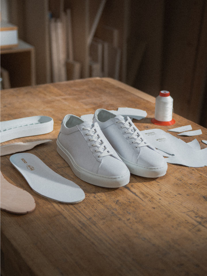 Mens Italian white leather sneakers with laces on a table