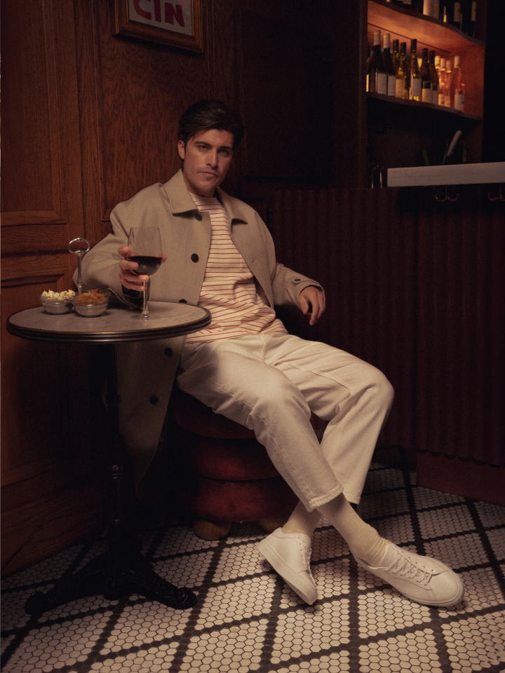 Man sitting wearing Italian men's white leather sneakers with laces