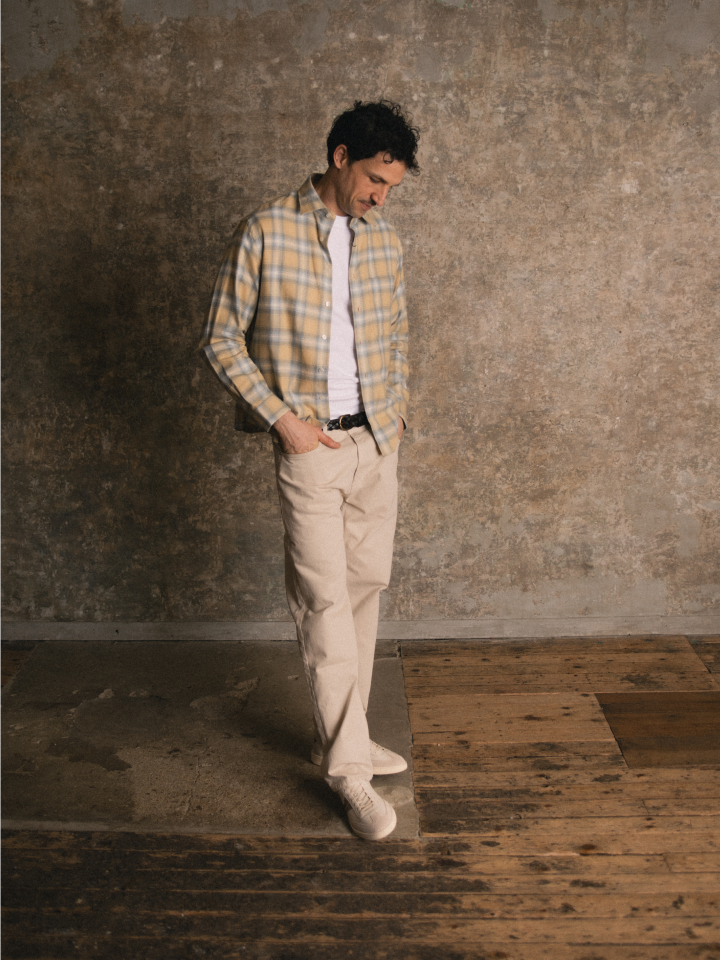 Man standing wearing Italian beige suede sneakers with laces